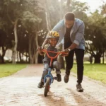 African father teaching his son to ride a bike