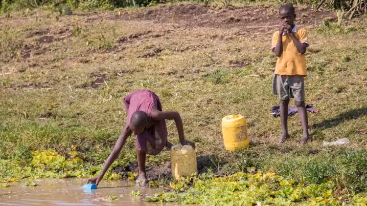 Children getting water from river to drink with buckets