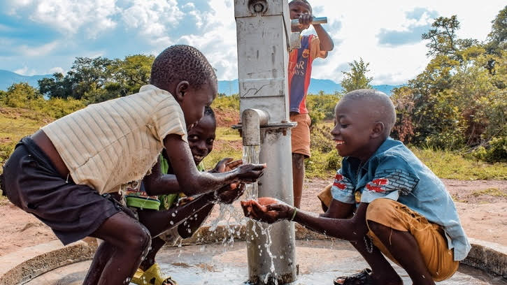 children smiling at water fountain