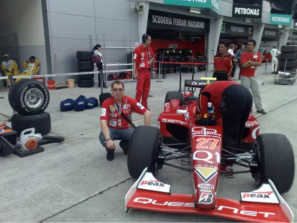 QNET history 2008 JR mayer inf ront of QI red Race car