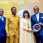 Bola Ray holding one of QNET's golden awards received at IPRA ceremony in Ghana